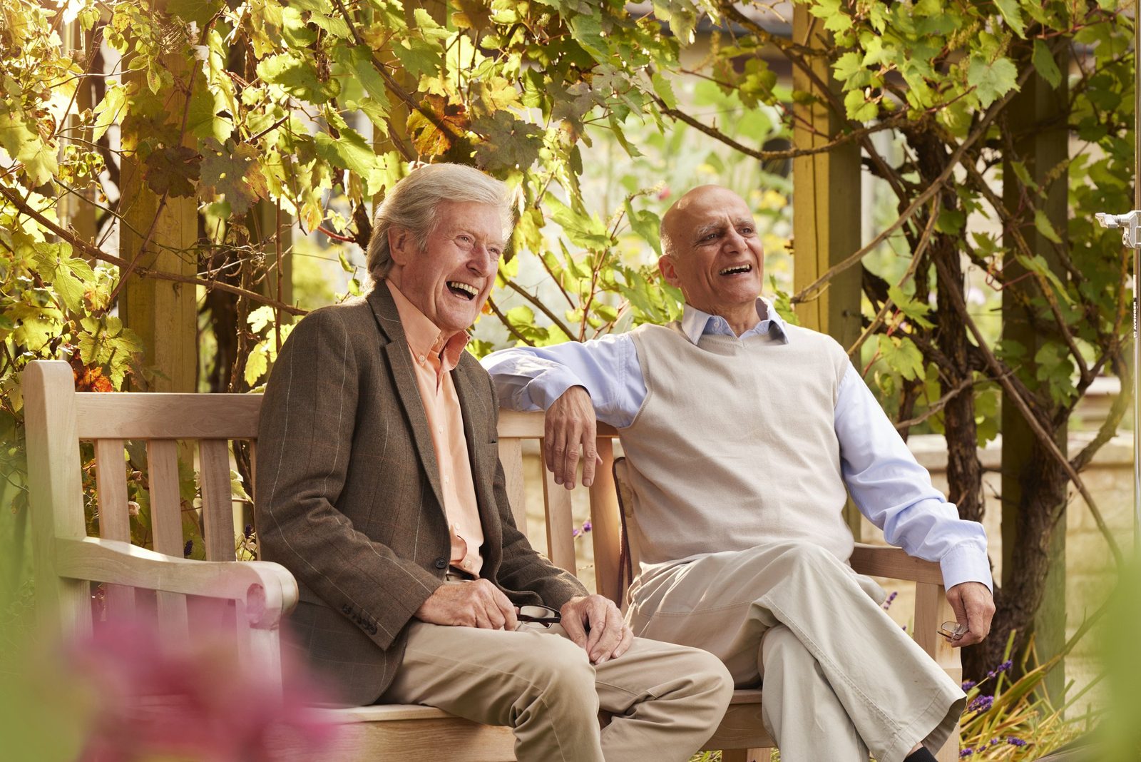 Elizabeth Finn Homes: two residents laughing together on a garden bench