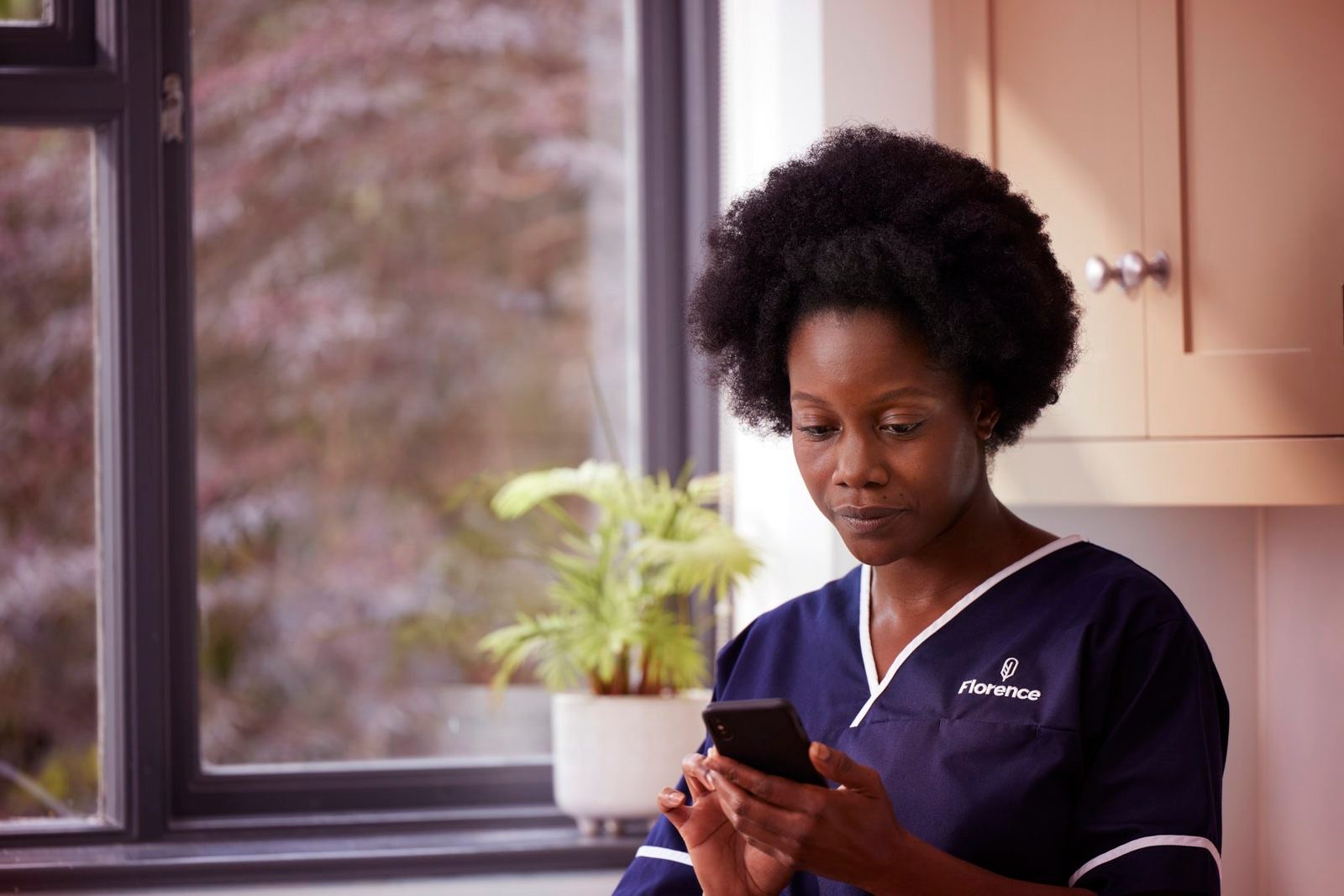 Florence: a nurse reading her phone by a window