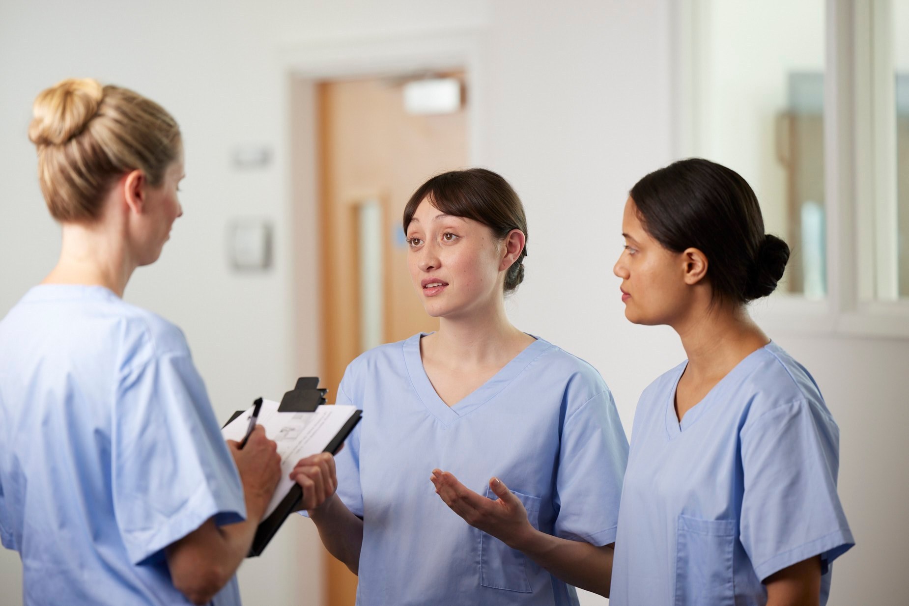 Florence: three nurses talking in a hospital corridor