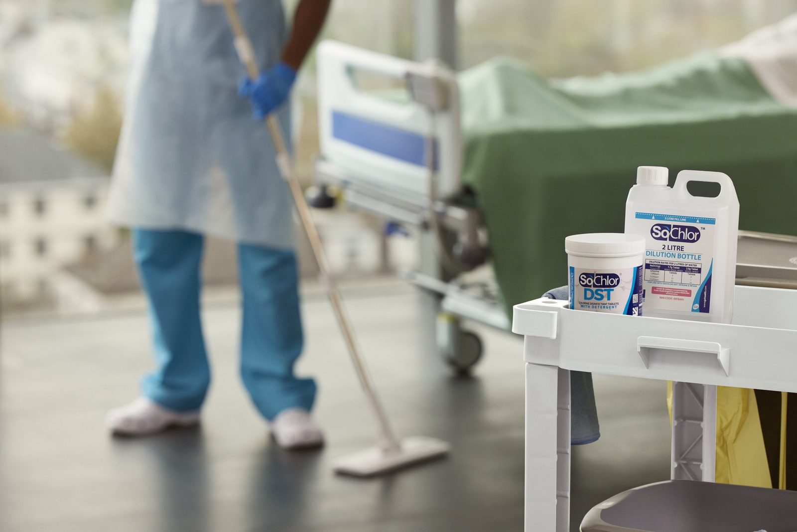 GV Health: a cleaner mopping a ward beside a trolley of SoChlor disinfectant