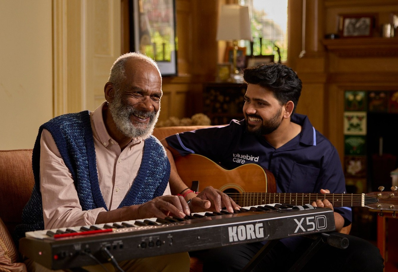 A carer playing guitar with a client, a 30-second Bluebird Care story